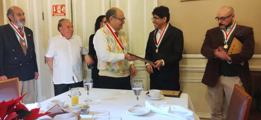 El maestro Raúl Gómez Espinoza entrega reconocimiento al Doctor Eber Omar Betanzos Torres. A la derecha el Maestro Israel González Delgado.